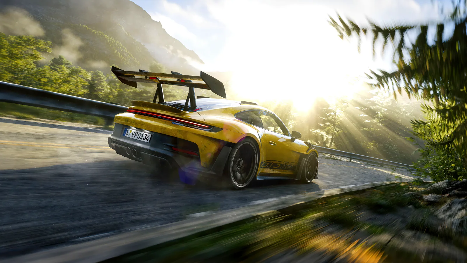 Yellow Porsche 911 GT3 RS driving on a sunlit mountain road
